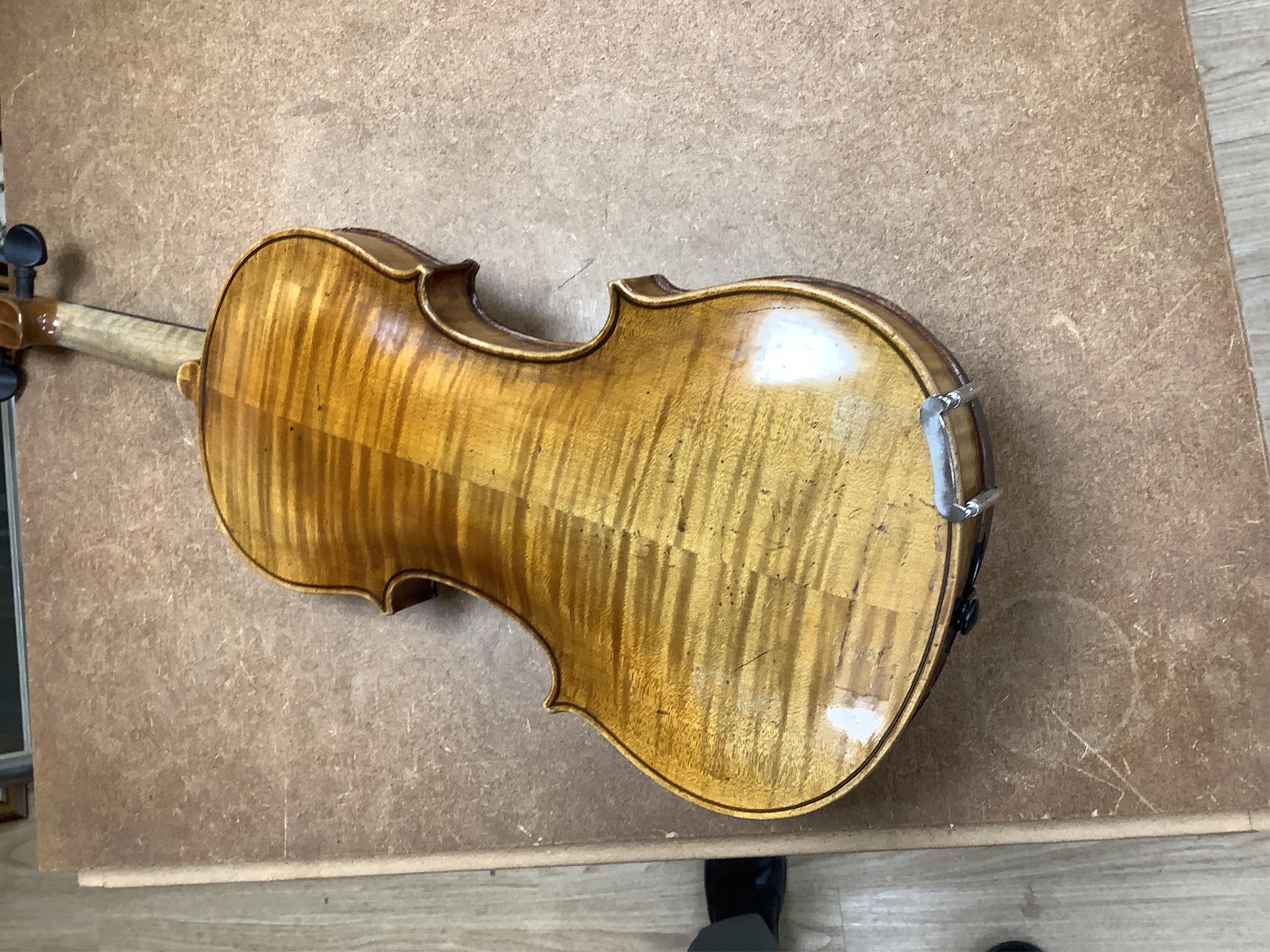 A cased 7/8 size 19th century violin, body 35cm, together with another cased violin, body 35.5cm, both without bows, and a spare case (3)